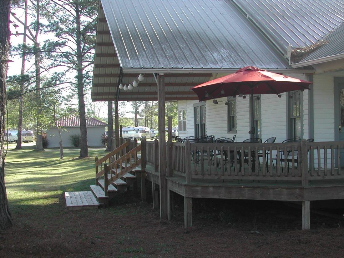 The clubhouse with its wraparound deck and shaded patio seating.